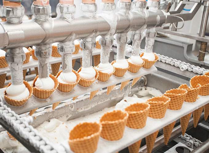 Abfüllanlage befüllt Waffelhörnchen mit Eiscreme – Einsatz von Präzisionsteilen der Martin Höhn GmbH in der Lebensmitteltechnik