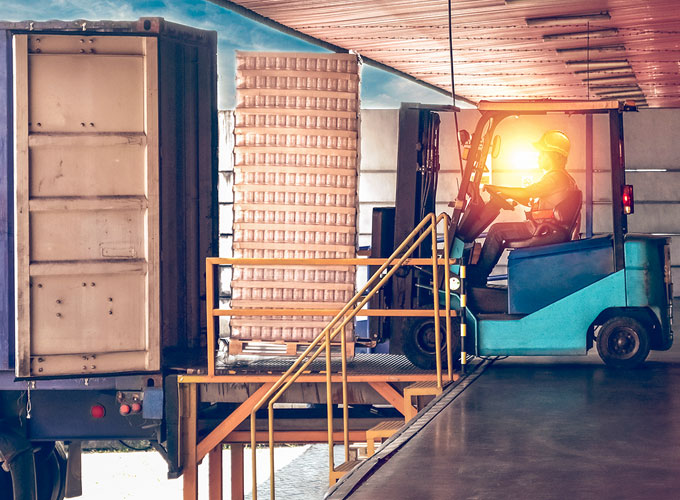 Gabelstaplerfahrer belädt einen rückwärts an einer Rampe stehenden LKW mit Waren – Logistikanwendung bei Martin Höhn GmbH