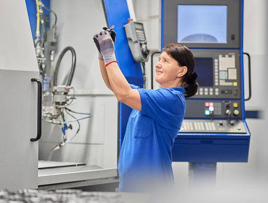 Mitarbeiterin der Martin Höhn GmbH führt präzises Laserschweißen an einem Bauteil durch
